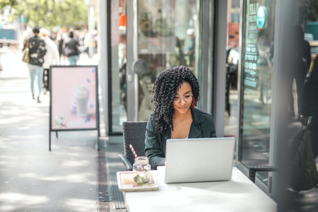 A woman sitting at a computer emailing blog owners about guest blogging opportunities.